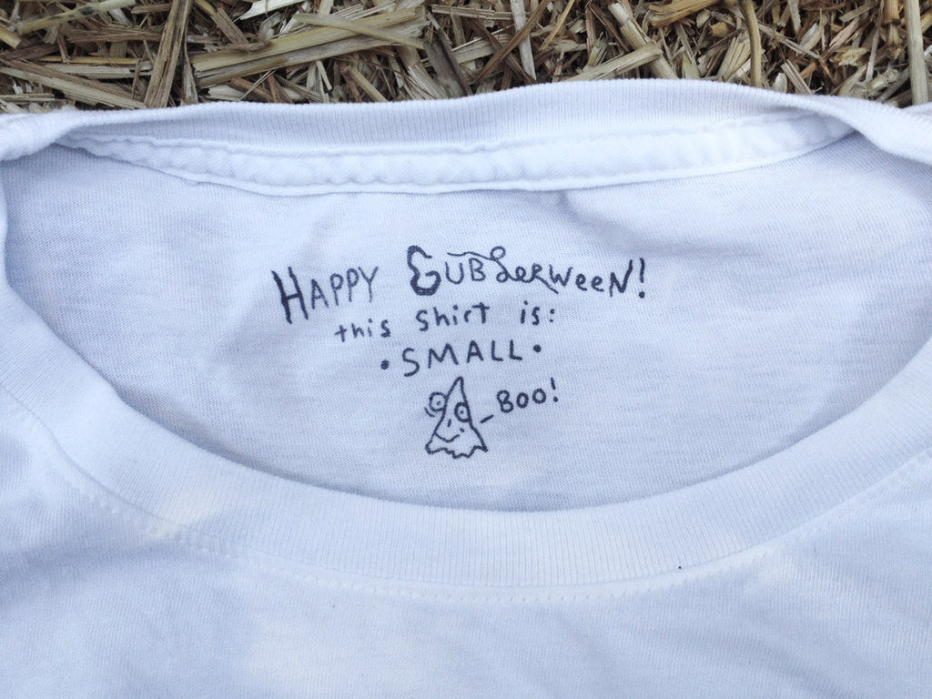 Hand-written text inside t-shirt that says “Happy Gublerween this shirt is small, Boo!”.