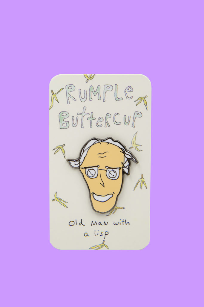 Image of enamel pin of Old Man with a Lisp character on top of paper card covered in hand-drawn bananas.