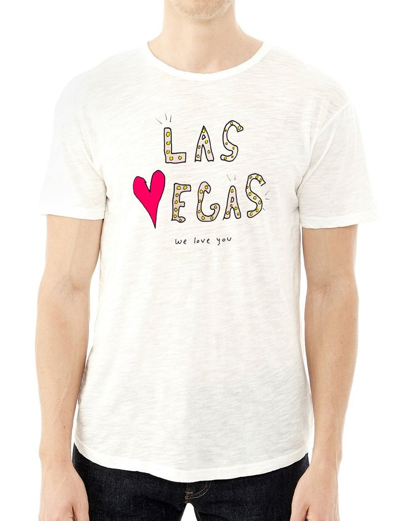 Picture of white t-shirt on a person with hand-drawn artwork that says “Las Vegas we love you”.