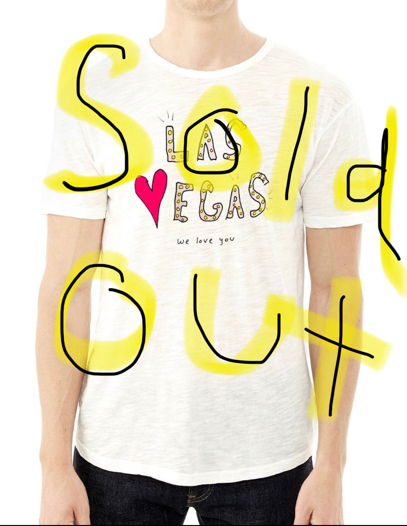 Picture of white t-shirt on a person with hand-drawn artwork that says “Las Vegas we love you”. Large hand-written text over image that says “Sold Out”.
