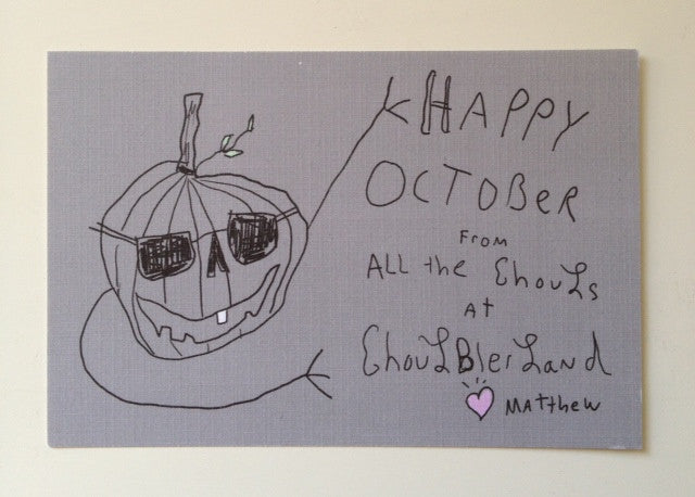 Notecard with drawing of pumpkin with arms and sunglasses along side handwritten lettering that says “Happy October from all the ghouls at Goulberland - Matthew”